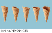 pattern of a different perspectives of waffle cone for ice cream on a blue background. perspectives of wafer sugar cone. Стоковое фото, агентство Ingram Publishing / Фотобанк Лори
