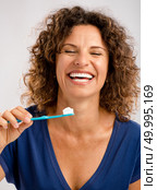 Beautiful mature woman brushing her teeths . Стоковое фото, агентство Ingram Publishing / Фотобанк Лори