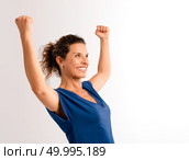 Portrait of a happy middle aged brunette with arms up expressing victory. Стоковое фото, агентство Ingram Publishing / Фотобанк Лори