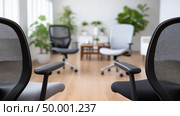 Office workspace with ergonomic chairs and indoor plants brightening the room. Стоковое AI-изображение, AI-художник Katsiaryna Repich / Фотобанк Лори