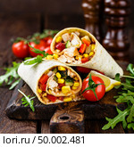 Burritos wraps with chicken meat and vegetables on wooden background. Стоковое фото, агентство Ingram Publishing / Фотобанк Лори
