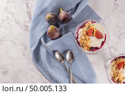 Figs pudding parfait with yogurt, blueberry jam, figs, hazelnut, and cookies in glass on white marble background. Flatlay top view. Стоковое фото, агентство Ingram Publishing / Фотобанк Лори
