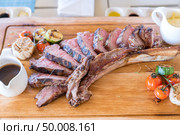 Grilled tomahawk steak on wooden plate. Стоковое фото, агентство Ingram Publishing / Фотобанк Лори