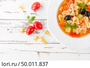Minestrone, vegetarian soup with pasta and vegetables on white wooden rustic background. Traditional italian food. Top view. Стоковое фото, агентство Ingram Publishing / Фотобанк Лори