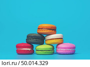 Cake macaron or macaroon on turquoise background from above, colorful almond cookies, pastel colors, vintage card. Стоковое фото, агентство Ingram Publishing / Фотобанк Лори