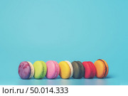 Cake macaron or macaroon on turquoise background from above, colorful almond cookies, pastel colors, vintage card. Стоковое фото, агентство Ingram Publishing / Фотобанк Лори