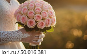 Close-up of woman's lace-gloved hands in wedding dress holding beautiful bouquet of pink roses outdoors bokeh. Woman moves slightly. For wedding and celebration. Стоковое AI-видео, аниматор Ольга Яковенко / Фотобанк Лори