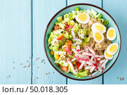 Bowl with wheat porridge, boiled quail eggs and fresh vegetable salad of radish, corn, sweet pepper and chinese cabbage. Healthy and delicious dietary lunch. Vegetarian, vegan food. Top view. Flat lay. Стоковое фото, агентство Ingram Publishing / Фотобанк Лори