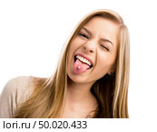 Studio portrait of a beautiful teenager girl showing her piercing in her tongue. Стоковое фото, агентство Ingram Publishing / Фотобанк Лори