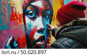 A woman is standing in front of a wall, using spray paint cans to create vibrant and colorful graffiti designs. Стоковое AI-изображение, AI-художник Данила Большаков / Фотобанк Лори