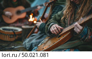A woman in casual attire is seated on the ground, strumming a guitar with focused concentration. Стоковое AI-изображение, AI-художник Данила Большаков / Фотобанк Лори