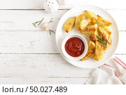 Potato baked and tomato ketchup on white plate, wooden background, top view. Стоковое фото, агентство Ingram Publishing / Фотобанк Лори