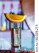 Gold tequila shot with orange on bar. close-up. Стоковое фото, агентство Ingram Publishing / Фотобанк Лори