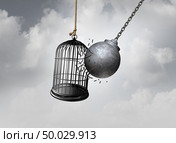 Freedom cage and break Free concept as a wrecking ball liberating a birdcage breaking open a prison as an abstract idea of escaping an addiction or detention hope as a 3D illustration. Стоковое фото, агентство Ingram Publishing / Фотобанк Лори
