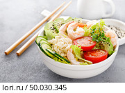 Hawaiian poke bowl with shrimps, rice and vegetables, healthy Buddha bowl with prawns, rice, avocado, cucumber, tomato and lettuce. Стоковое фото, агентство Ingram Publishing / Фотобанк Лори