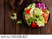 Buddha bowl dish. Healthy balanced lunch with quinoa, grilled chicken meat, lettuce salad, pepper, cucumber, tomato and avocado guacamole with lemon. Стоковое фото, агентство Ingram Publishing / Фотобанк Лори