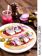 Delicious grilled sandwiches with herring, onion and beetroot sauce with horseradish on dark wooden rustic background. Danish cuisine. Стоковое фото, агентство Ingram Publishing / Фотобанк Лори