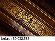 Detailed image showcasing an ornate golden and brown inlay pattern. Стоковое фото, фотограф EugeneSergeev / Фотобанк Лори