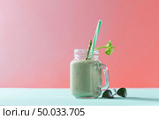 Vegetarian healthy mix from vegetables with green leaves and plastic straw in a glass jar on duotone background in a color of the year 2019 Living Coral Pantone.. Green homemade smoothie from organic vegetables with asparagus and celery in a mason jar on duotone background in color of the year 2019 Living Coral Pantone. Стоковое фото, агентство Ingram Publishing / Фотобанк Лори