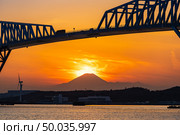 Diamond Fuji in Tokyo with Tokyo Gate Bridge, natural phenomenons that sun move pass mountain Fuji while sunset in Tokyo Japan. This happen only 2 times once a year. Стоковое фото, агентство Ingram Publishing / Фотобанк Лори