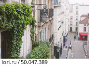 Paris, France - May 22, 2012: Houses on Montmartre street in Paris,in the spring day view from a height.. Paris, France - May 22, 2012: View from the heights, to the street and houses of the city on a spring afternoon. Редакционное фото, агентство Ingram Publishing / Фотобанк Лори