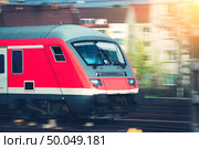 High speed passenger train on tracks in motion at sunset. Commuter train. Railway station in Nuremberg, Germany. Railroad with vintage toning. Стоковое фото, агентство Ingram Publishing / Фотобанк Лори