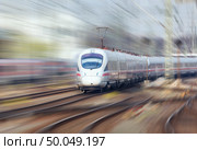 Railway station with modern high speed train in motion in the evening in Nuremberg, Germany. White train on the railroad track. Motion blur effect. Стоковое фото, агентство Ingram Publishing / Фотобанк Лори