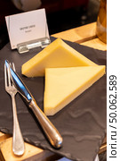 gruyere cheese on black stone plate in buffet line. Стоковое фото, агентство Ingram Publishing / Фотобанк Лори
