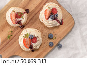 Small pavlova cakes with fresh raspberries and blueberries. Стоковое фото, агентство Ingram Publishing / Фотобанк Лори
