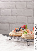 Small pavlova cakes with fresh raspberries and blueberries. Стоковое фото, агентство Ingram Publishing / Фотобанк Лори