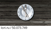 Intermittent fasting and calorie restriction or autophagy diet symbol nutrition concept promoting healthy benefits for prolonging lifespan with a clock icon on a plate with knife and fork with 3D illustration elements. Стоковое фото, агентство Ingram Publishing / Фотобанк Лори