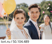 Счастливые молодожены на свадьбе с воздушными шарами у озера в солнечный день. Стоковое AI-изображение, AI-художник Сергей Никифоров-Гордеев / Фотобанк Лори