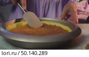 Spreading apple filling on pie crust in a kitchen setting. Стоковое видео, видеограф Zakharova Natasha / Фотобанк Лори
