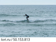A middle aged man doing some foil surfing or hydrofoil surfing in the sea. Стоковое фото, агентство Ingram Publishing / Фотобанк Лори