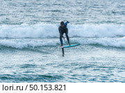 A middle aged man doing some foil surfing or hydrofoil surfing in the sea. Стоковое фото, агентство Ingram Publishing / Фотобанк Лори