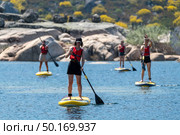 Stand up paddleboarding on lake. Watersport on lake. Tourist outdoor activity at Lagoa Comprida, Serra da Estrela National Park in Portugal. Стоковое фото, агентство Ingram Publishing / Фотобанк Лори