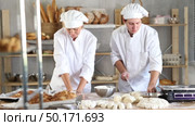 Male and female bakers knead dough, cut and weigh pieces. Стоковое видео, видеограф Яков Филимонов / Фотобанк Лори