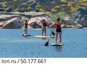Stand up paddleboarding on lake. Watersport on lake. Tourist outdoor activity at Lagoa Comprida, Serra da Estrela National Park in Portugal. Стоковое фото, агентство Ingram Publishing / Фотобанк Лори