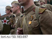 Люди в форме солдат и с оружием Великой Отечественной войны идут по Красной площади в центре города Москвы, Россия. Редакционное фото, фотограф Николай Винокуров / Фотобанк Лори