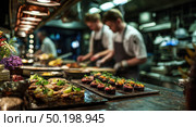 A group of chefs are preparing food in a kitchen. Стоковое AI-изображение, AI-художник Ярославский Максим / Фотобанк Лори