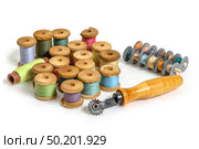 Wooden spools of colorful thread with old metal bobbins and rusty hand roll cutter. Стоковое фото, фотограф Camptoloma / Фотобанк Лори