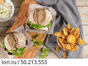 Healthy vegan burger with fresh vegetables and yogurt sauce on rustic kitchen counter top. Стоковое фото, агентство Ingram Publishing / Фотобанк Лори