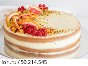 Homemade vanilla birthday cake decorated with orange, peach and gooseberries isolated on table tob. Celebration, party cake. Стоковое фото, агентство Ingram Publishing / Фотобанк Лори