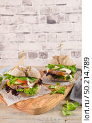 Healthy vegan burger with fresh vegetables and yogurt sauce on rustic kitchen counter top. Стоковое фото, агентство Ingram Publishing / Фотобанк Лори