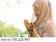 Young Adult teenager Woman making Duas for Muslim god blessing prayer. Стоковое фото, агентство Ingram Publishing / Фотобанк Лори