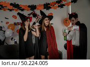 Group of young adult and teenager people celebrating a Halloween party carnival Festival in Halloween costumes drinking alcohol beer and dancing. Стоковое фото, агентство Ingram Publishing / Фотобанк Лори