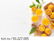 Orange juice. Freshly squeezed juice in glasses and fresh fruits with leaves, view from above. Стоковое фото, агентство Ingram Publishing / Фотобанк Лори