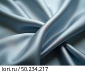 Soft blue silk cascades gracefully, creating delicate curves and smooth lines. The fabric catches ambient light, revealing a luxurious sheen and inviting touch, perfect for design Generative AI. Стоковое AI-изображение, AI-художник Юлия Петровская / Фотобанк Лори