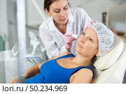 Young female cosmetologist doing microcurrent procedure to adult woman. Стоковое фото, фотограф Яков Филимонов / Фотобанк Лори