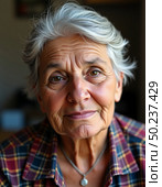 A senior woman smiles gently, showcasing her silver hair and warm expression. Dressed in a plaid shirt, she radiates wisdom and a sense of comfort in a softly lit room Generative AI. Стоковое AI-изображение, AI-художник Юлия Петровская / Фотобанк Лори